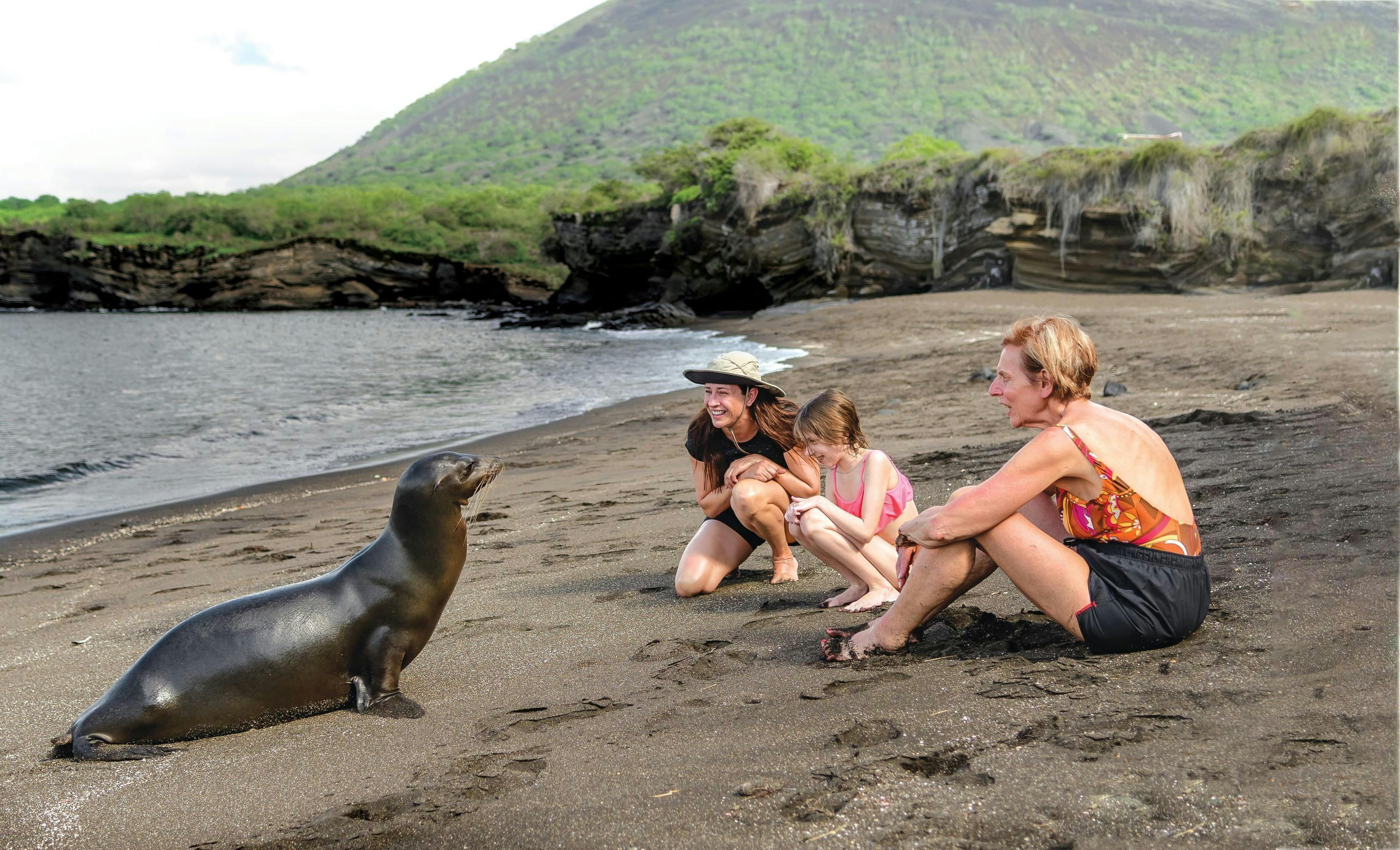 Sea Lion and Lindblad Expeditions Guests on Puerto Egas, Santiago Island,  in the Galapagos Islands, Ecuador.