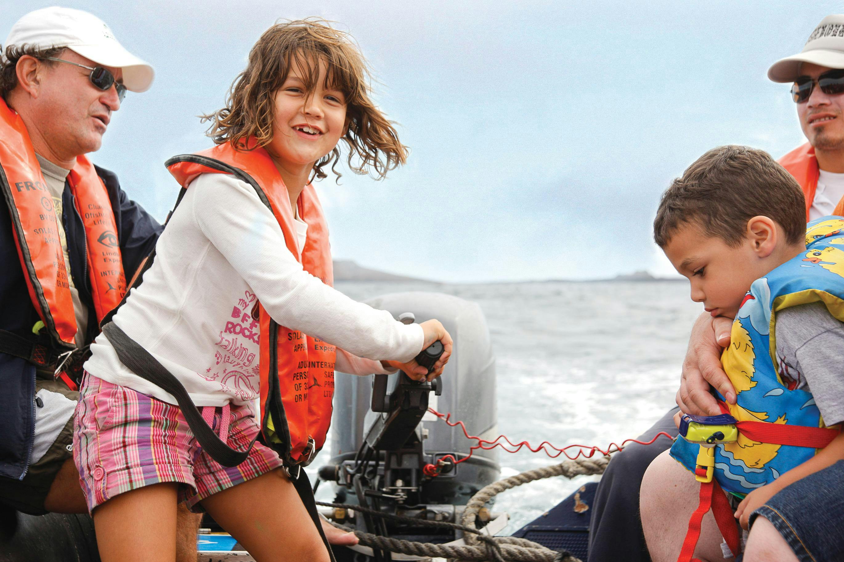 A young explorer learning how to operate a zodiac in Galapagos, Ecuador.