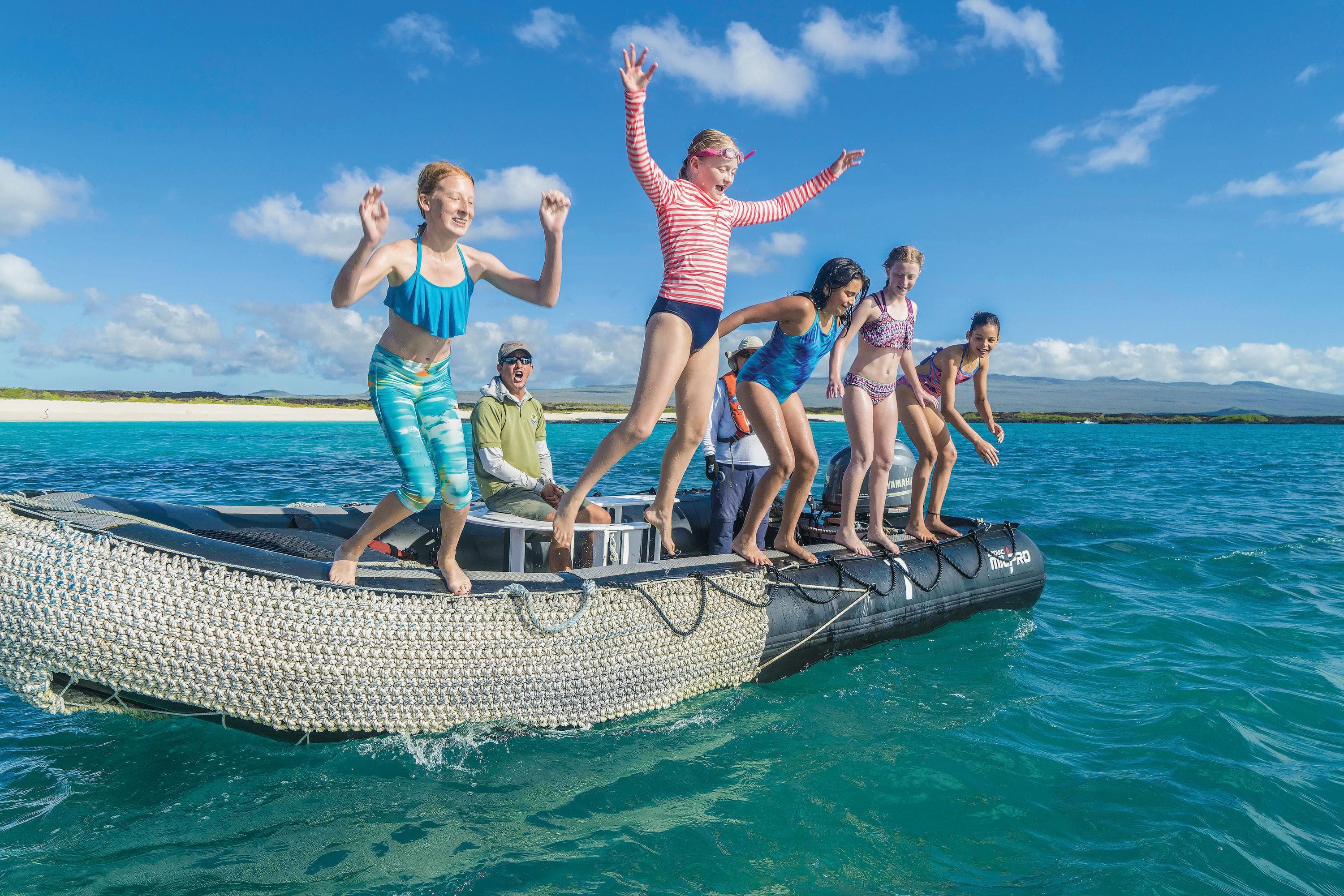 Kids taking a swim off a Zodiac in Ecuador, Galapagos Inslands, South America.